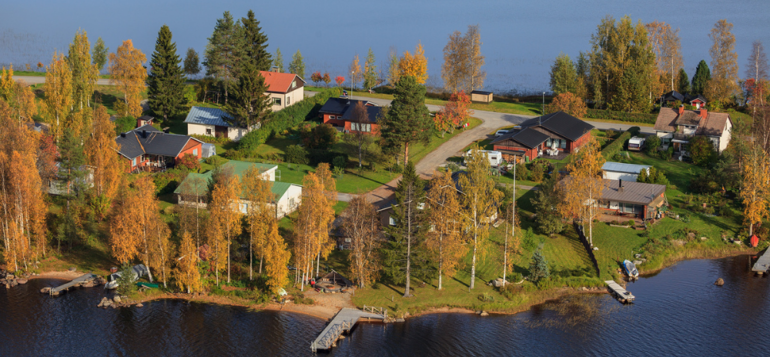 Kuva pienestä saaresta, jossa on taloja ja puita.