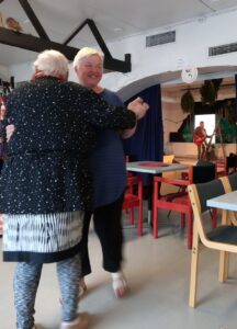 Iloksi ry:n jäsenet tanssimassa livemusiikin tahtiin työväentalon kahviossa