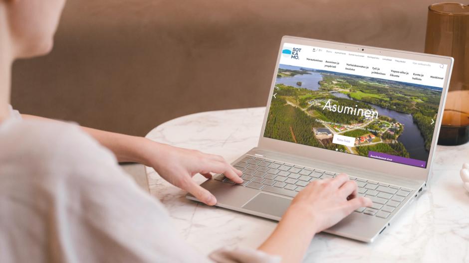 Nainen on kannettavalla tietokoneella Sotkamon verkkosivuilla.