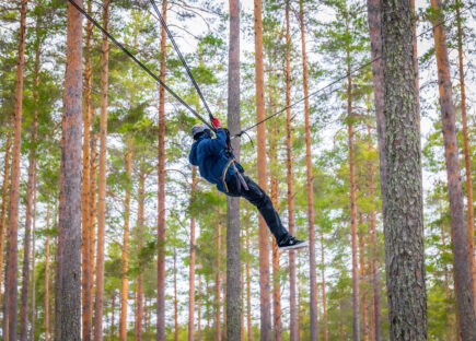 Kipinäpäivillä nuorille järjestetään erilaisia toiminnallisia harjoituksia, kuten seikkailua. Kuvassa nuori on valjassa puiden välissä.