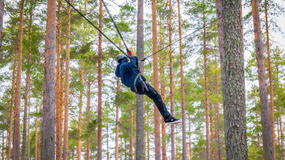 Kipinäpäivillä nuorille järjestetään erilaisia toiminnallisia harjoituksia, kuten seikkailua. Kuvassa nuori on valjassa puiden välissä.