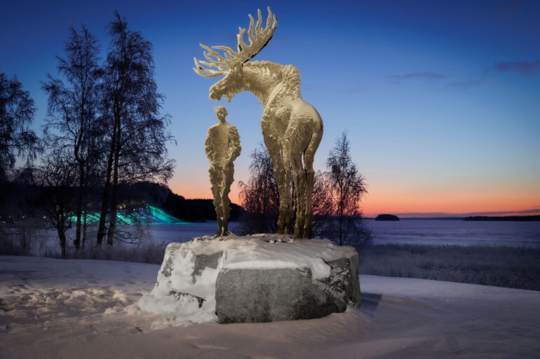Havukka-ahon ajattelija patsas Hirvensalmella taustanaan Hiukan elämysvalot ja kaunis auringonlasku talvella.