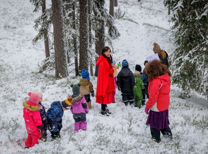 "Punahilkka" lapsiryhmän kanssa lumisessa metsässä.