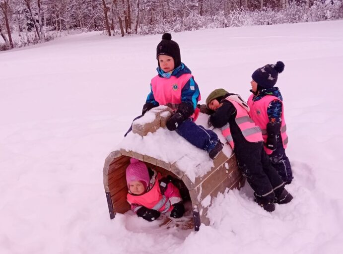 Talvinen leikkipaikka, neljä lasta leikkimässä.