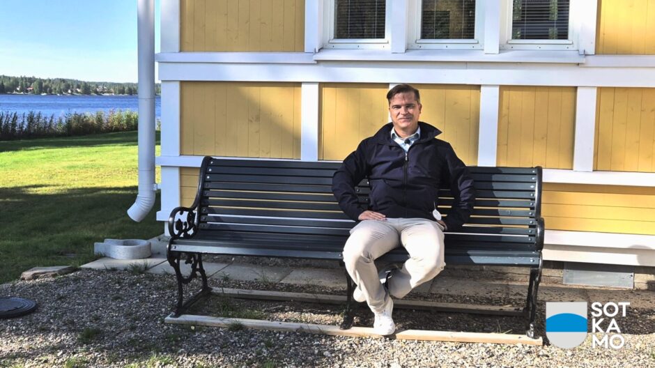 Kunnanjohtaja istuu puutarhatuolissa Aatoksen edessä aurinkoisella kelillä