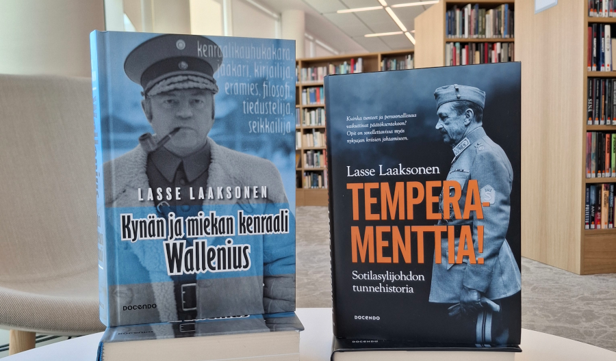 Kaksi Lasse Laaksosen teosta, Kynän ja miekan kenraali Wallenius sekä Temperamenttia! : sotilasylijohdon tunnehistoria, kuvattuna kirjastossa.