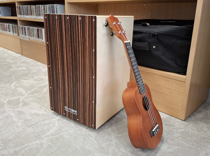 Kirjaston lainattava cajon-rumpu ja ukulele.